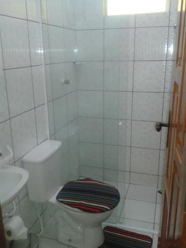 a white bathroom with a toilet and a shower at Chalés Ponta de Pedras in Alter do Chao