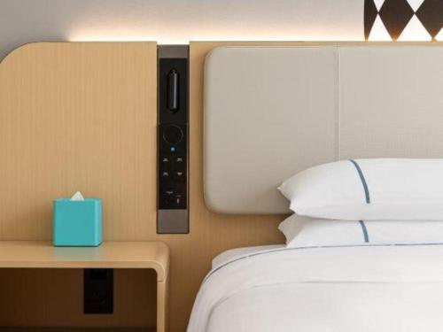 a bedroom with a bed and a nightstand with a blue box at City Comfort Inn Shiyan Wudang Mountain in Danjiangkou