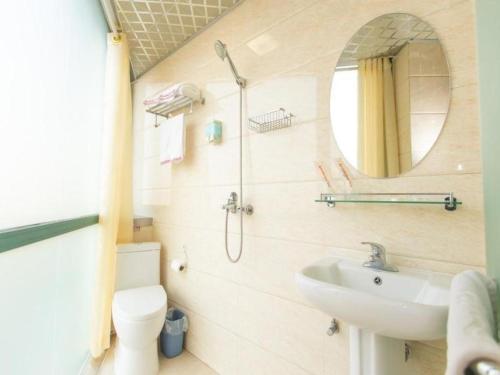 a bathroom with a sink and a toilet and a mirror at Shell Hotel Yangzhou Yangzijiang Bei Road Slender West Lake Scenic Area in Yangzhou