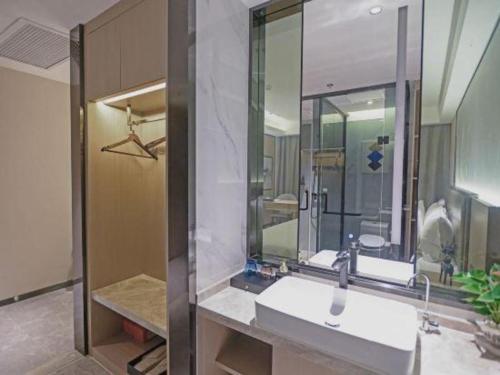 une salle de bain avec un lavabo et un miroir dans l'établissement Gya Hotel Nantong Nanshang Lake Street Wanda Plaza, à Nantong