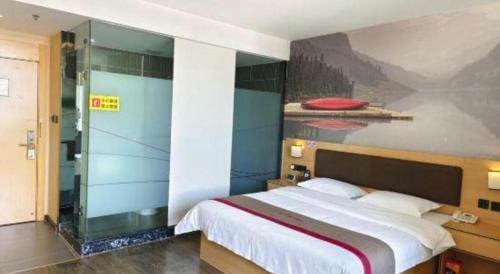a bedroom with a bed and a painting on the wall at Thank Inn Plus Hotel Guangdong Yunfu Luoding City Municipal in Yunfu