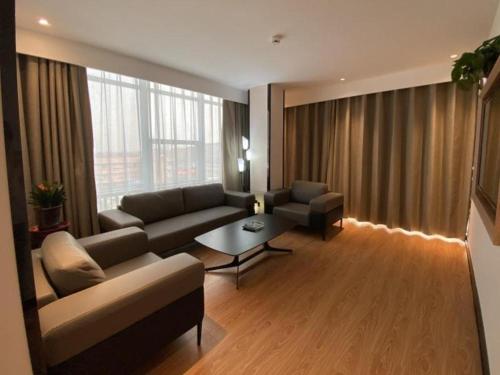 a living room with a couch and a table at GreenTree Inn Express Shandong Jinin Jiaxiang Railway Station in Jining