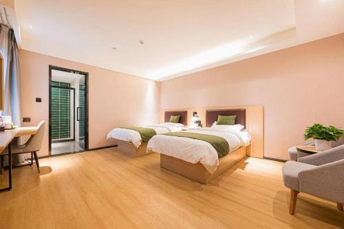 two beds in a large room with a desk and a desk at GreenTree Inn Express Chuzhou Langya District Government Chuhe Road in Chuzhou