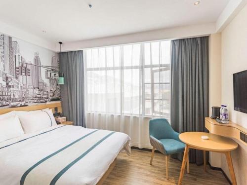 a hotel room with a bed and a table and a window at City Comfort Inn Lhasa Potala Palace Scenic View in Lhasa