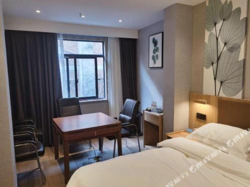 a hotel room with a desk and a bed at Green Tree Inn Express Huainan Xiejiaji District Orient Guangji Hospital in Huainan