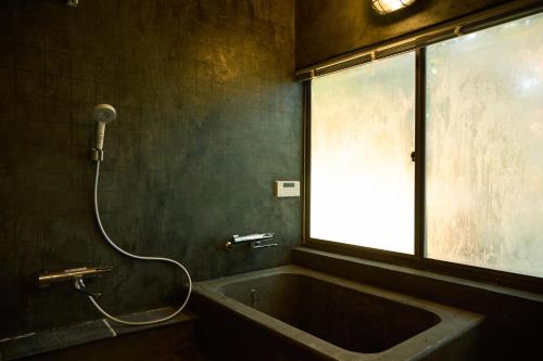 a bathroom with a bath tub and a window at nasusatoyamafield in Otawara