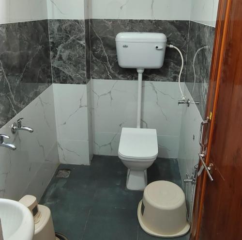 a bathroom with a white toilet and a sink at Anjali Mahal Resort in Goa