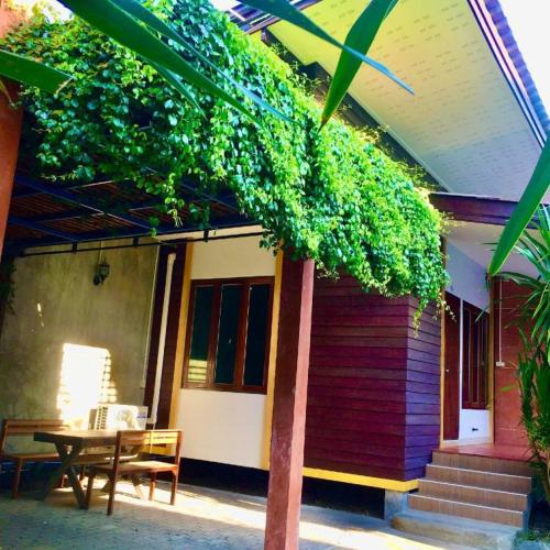 a house with a table and a tree in front of it at Kidthuengpark in Si Racha
