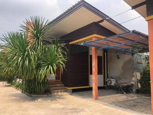 a house with two palm trees in front of it at Kidthuengpark in Si Racha