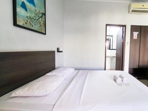 a bedroom with a bed with two white pillows on it at Wisma Griyaku 1 in Purbolinggo