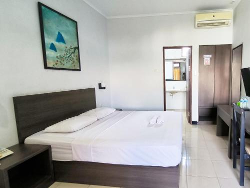 a bedroom with a large white bed in a room at Wisma Griyaku 1 in Purbolinggo