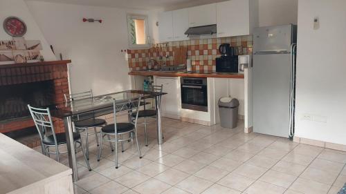 une cuisine avec une table, des chaises et un réfrigérateur dans l'établissement Casapiana, à Porto-Vecchio