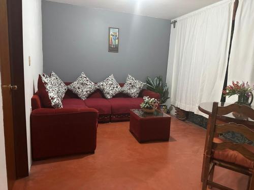 a living room with a red couch and a table at Departamento en el centro de Oaxaca in Oaxaca City