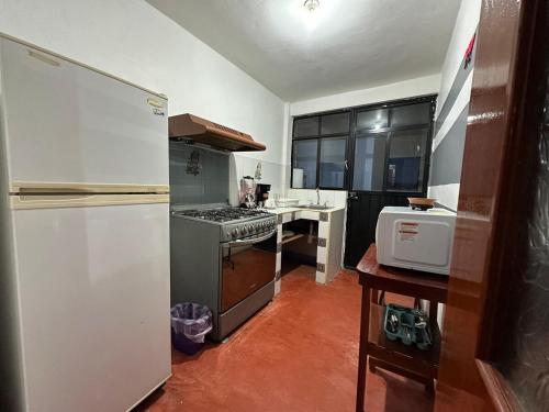 a kitchen with a stove and a refrigerator at Departamento en el centro de Oaxaca in Oaxaca City