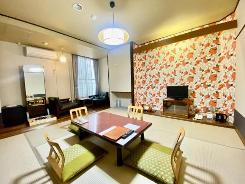 a living room with a dining room table and chairs at Oka Hotel in Kanazawa
