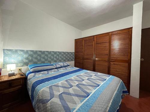 a bedroom with a bed and a wooden cabinet at Departamento en el centro de Oaxaca in Oaxaca City