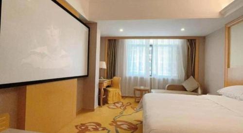 a hotel room with a projection screen and a bed at Vienna Hotel Guangxi Fangcheng in Fangcheng