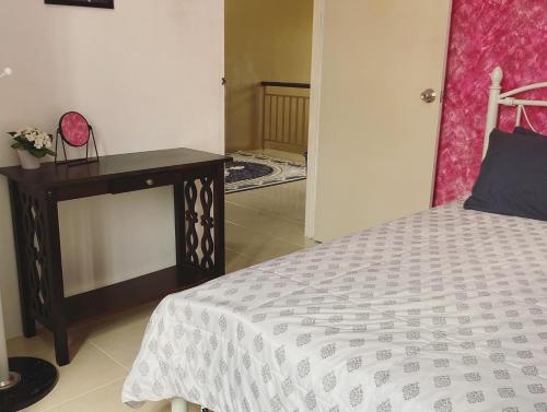 a bedroom with a bed and a nightstand with a bed sidx sidx at The Deck Homestay & Event House in Jitra