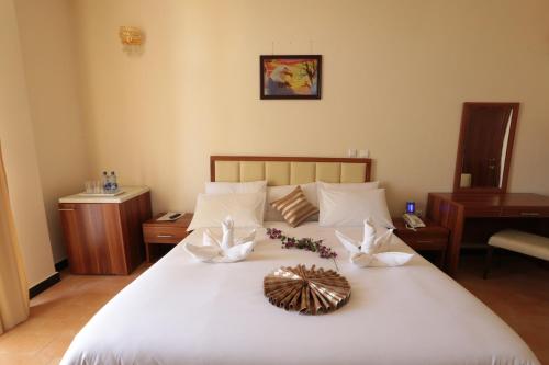 a bedroom with a large white bed with flowers on it at Bete Daniel Hotel in Bahir Dar