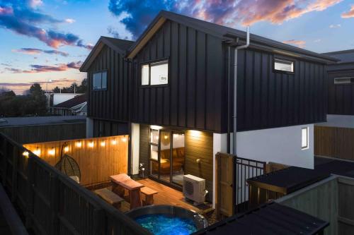 a house with a hot tub on a balcony at Cozy Retreat with Hot Tub in Christchurch
