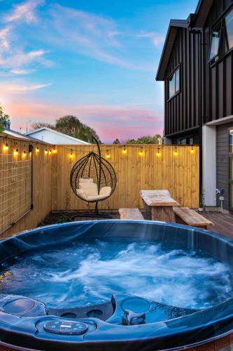 a hot tub on the patio of a house at Cozy Retreat with Hot Tub in Christchurch