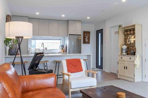 a living room with a couch and a kitchen at Cozy Retreat with Hot Tub in Christchurch