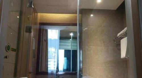 a bathroom with a mirror and a shower at Vienna Hotel Zhejiang Lishui Qingtian Post Building in Lishui