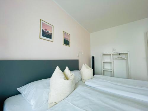 a bedroom with two beds with white pillows at APSTAY City Center I FREE Parking I Self Check-in in Graz