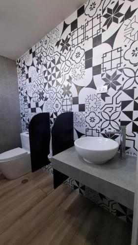 a bathroom with two sinks and a tile wall at VICTORIA COLOR Hotel in Tacna