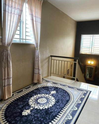 a room with a blue rug on the floor with a window at The Deck Homestay & Event House in Jitra