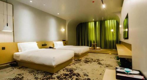 a hotel room with two beds and a large room at Borrman Hotel Jining High-tech Huangtun in Jining