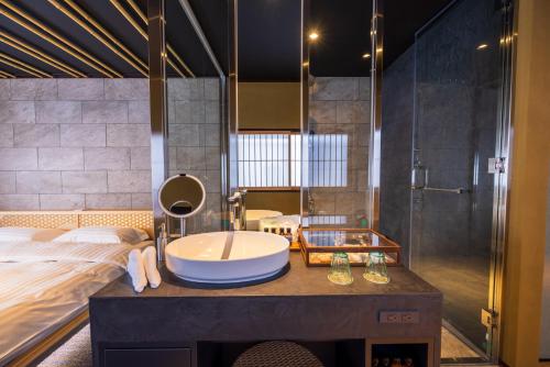 a bathroom with a sink and a bed and a tub at Kinnotake Saryo in Hakone