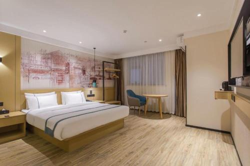 une chambre d'hôtel avec un lit et une table dans l'établissement City Comfort Inn Changning Wangchao, à Changning