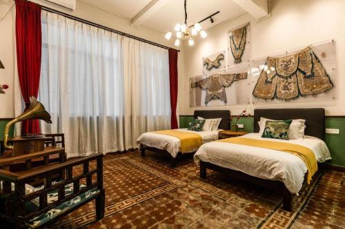 a room with two beds and a table and a room with two beds at Origin Antique House and Hotel in Guangzhou