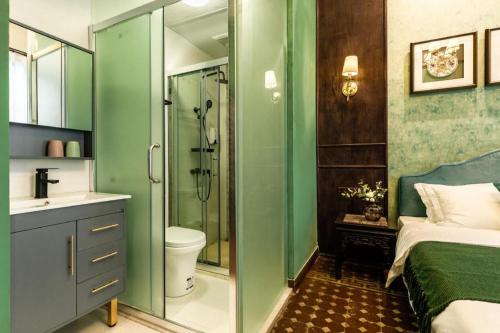 a green bathroom with a toilet and a shower at Origin Antique House and Hotel in Guangzhou