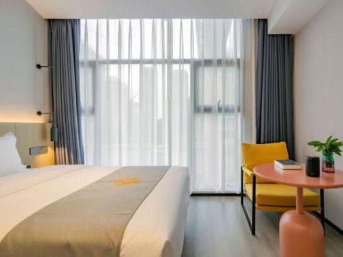 a hotel room with a bed and a table and a window at Airfeel Hotel in Ziyang