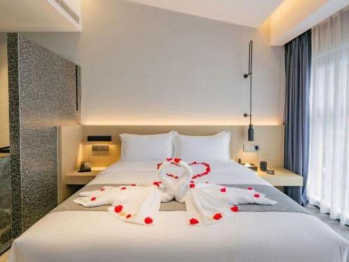 a large white bed with red decorations on it at Airfeel Hotel in Ziyang