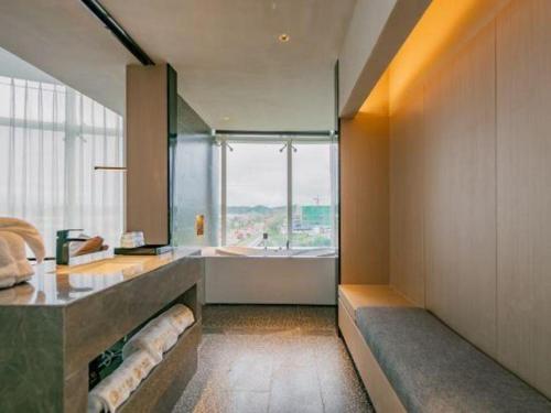 a large bathroom with a tub and a large window at Airfeel Hotel in Ziyang