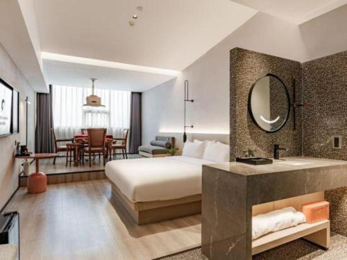 a hotel room with a bed and a bathroom at Airfeel Hotel in Ziyang
