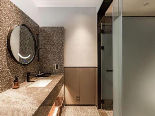 a bathroom with a sink and a mirror at Airfeel Hotel in Ziyang