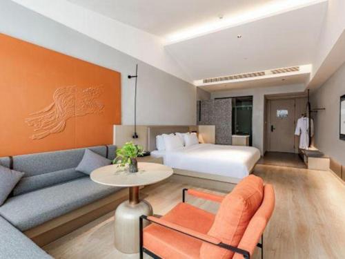 a hotel room with a couch and a bed at Airfeel Hotel in Ziyang