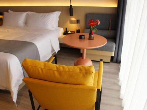 a hotel room with a bed and a table and a chair at Airfeel Hotel in Ziyang