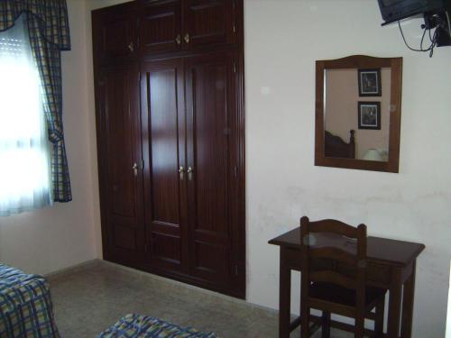 a room with a table and a mirror and a chair at Hostal El Polígono in Lucena