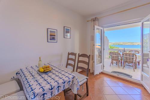 a dining room with a table and a view of the ocean at Rajka in Kustići