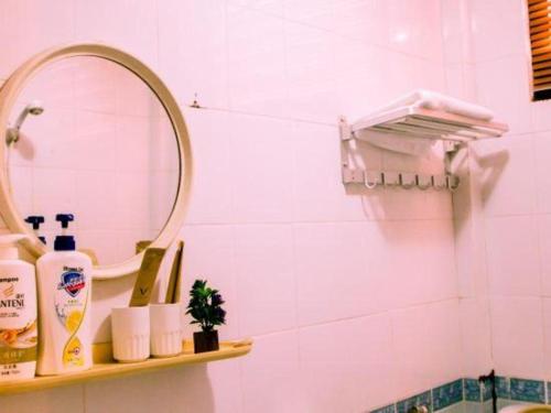 a bathroom with a mirror and a shelf with toiletries at New Lao Paris Hotel in Vientiane