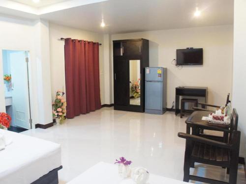 a living room with a table and a refrigerator at Nan Treasure Hotel in Nan