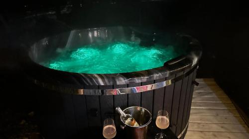a jacuzzi tub with blue water in it at La Știubei Cabin in Mărişel