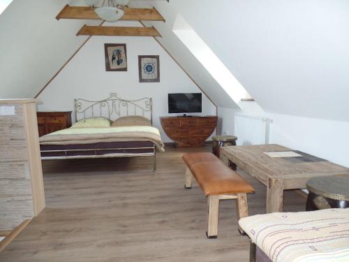 a attic bedroom with two beds and a table at Penzion u Ungerů in Dětenice