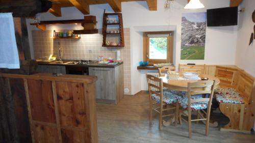 Una cocina con una mesa y sillas en una habitación. en La Luge, en Saint-Christophe