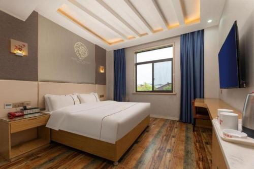 una camera da letto con un grande letto bianco e una finestra di Shell Hotel Jiangsu Kunshan Lujia Town Youyi Road a Suzhou